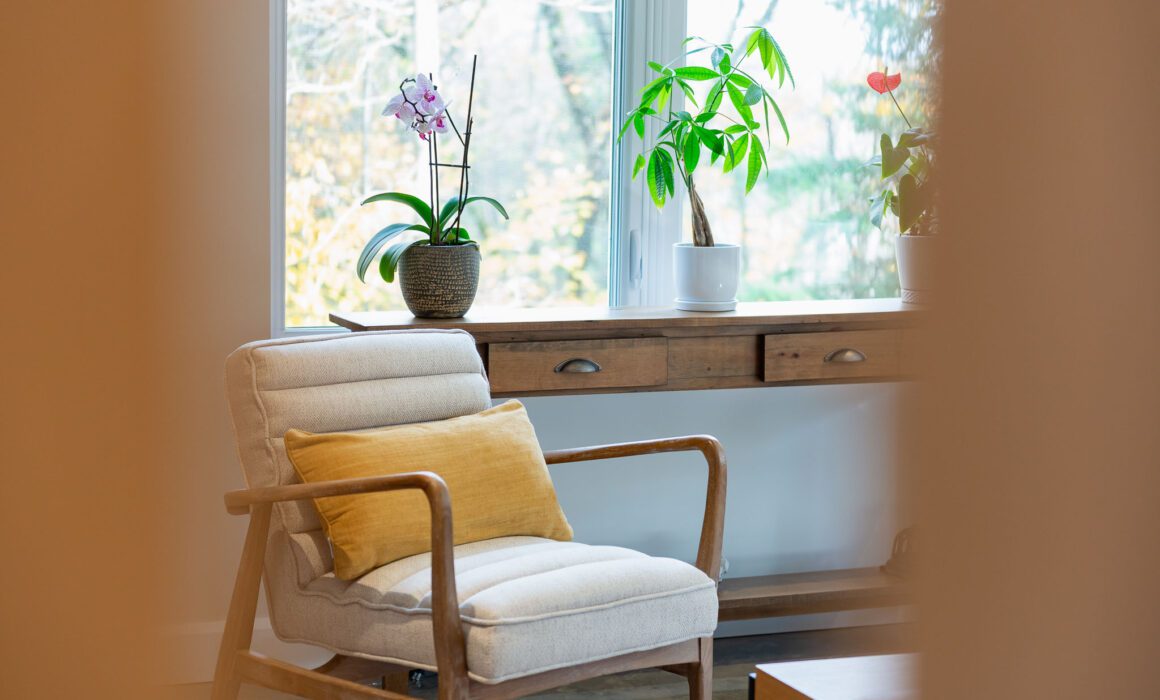 Un coin lecture où la lumière danse sur les feuillages et les textures naturelles, invitant à la lenteur et au doux confort du moment.